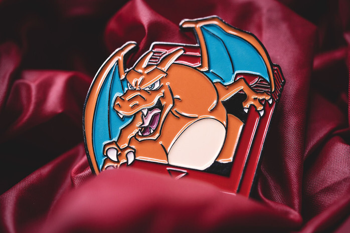 Orange dragon character trading pin on red satin